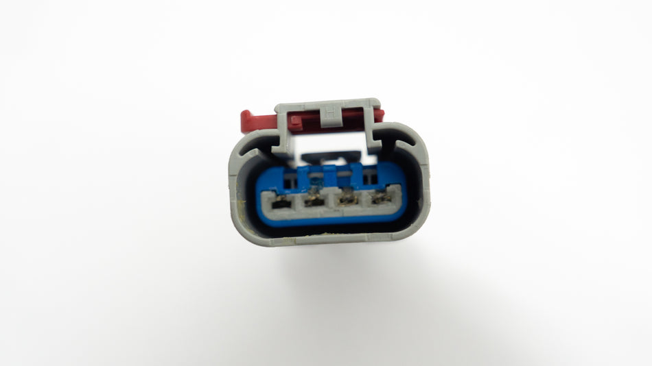 Close-up of a small electrical 4-pin connector on a white background