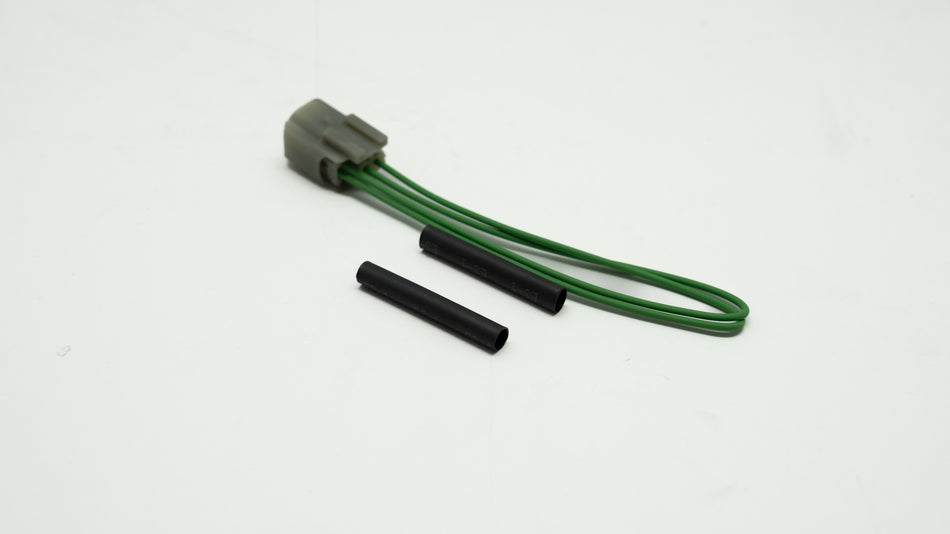 Green wiring kit with connector and black parts on a white background