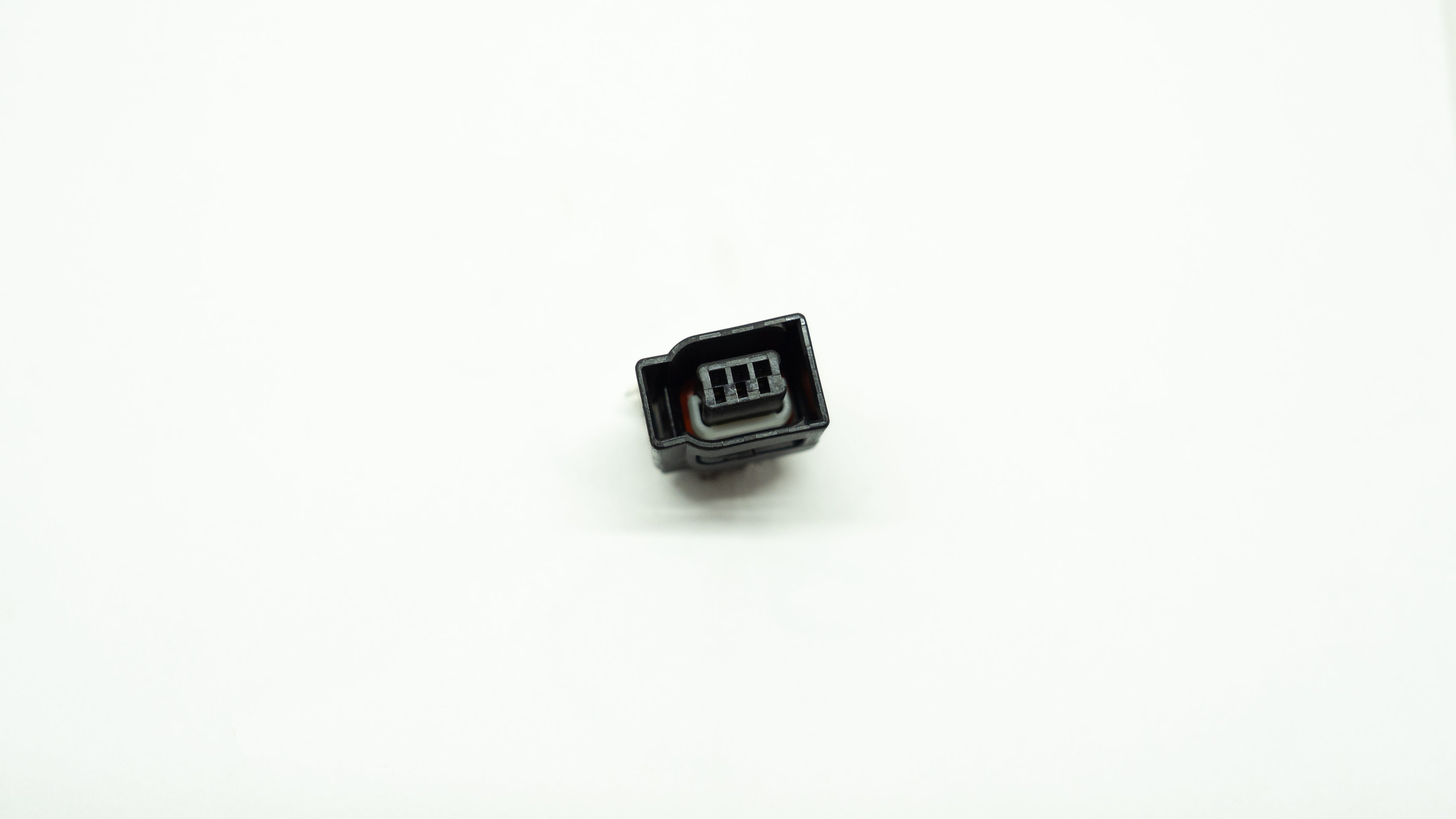 Small black electronic connector on a white background