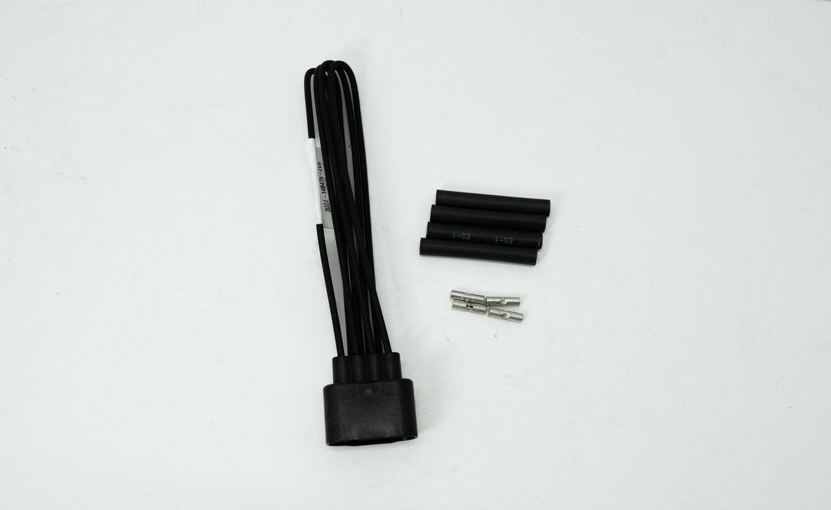Black automotive wiring kit with connectors and other parts on a white background. 