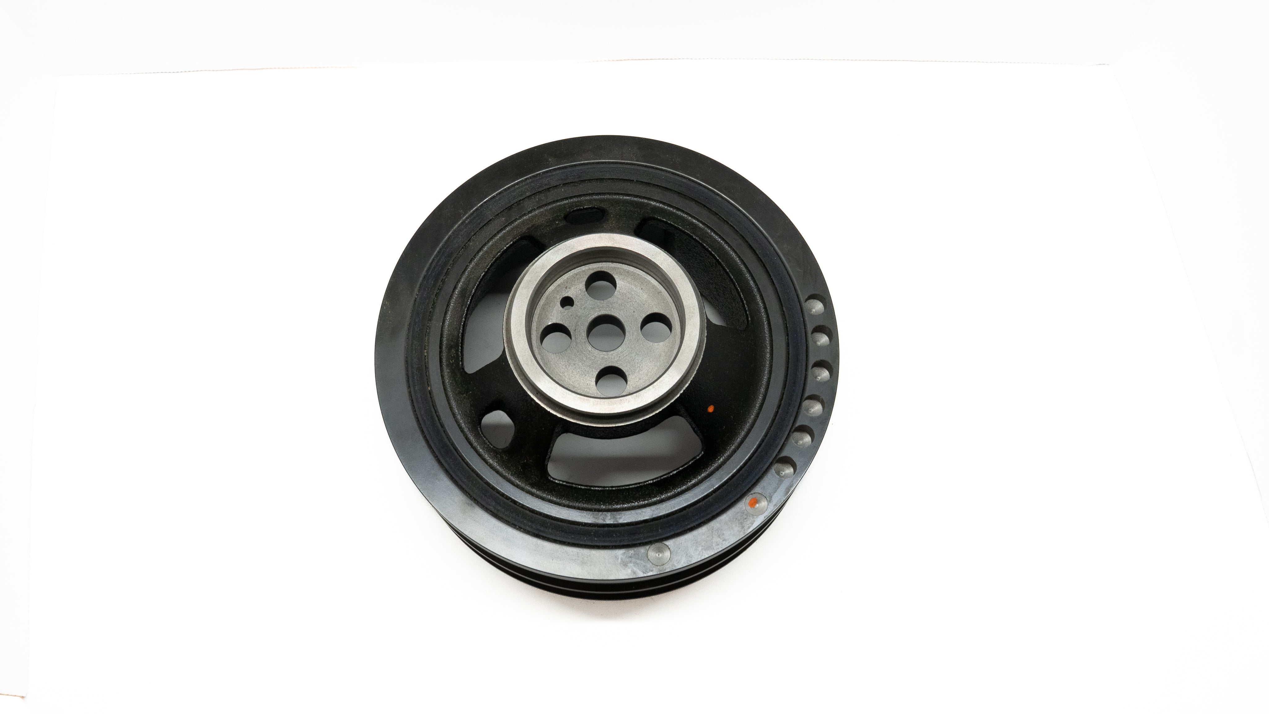 Black automotive crankshaft pulley on a white background
