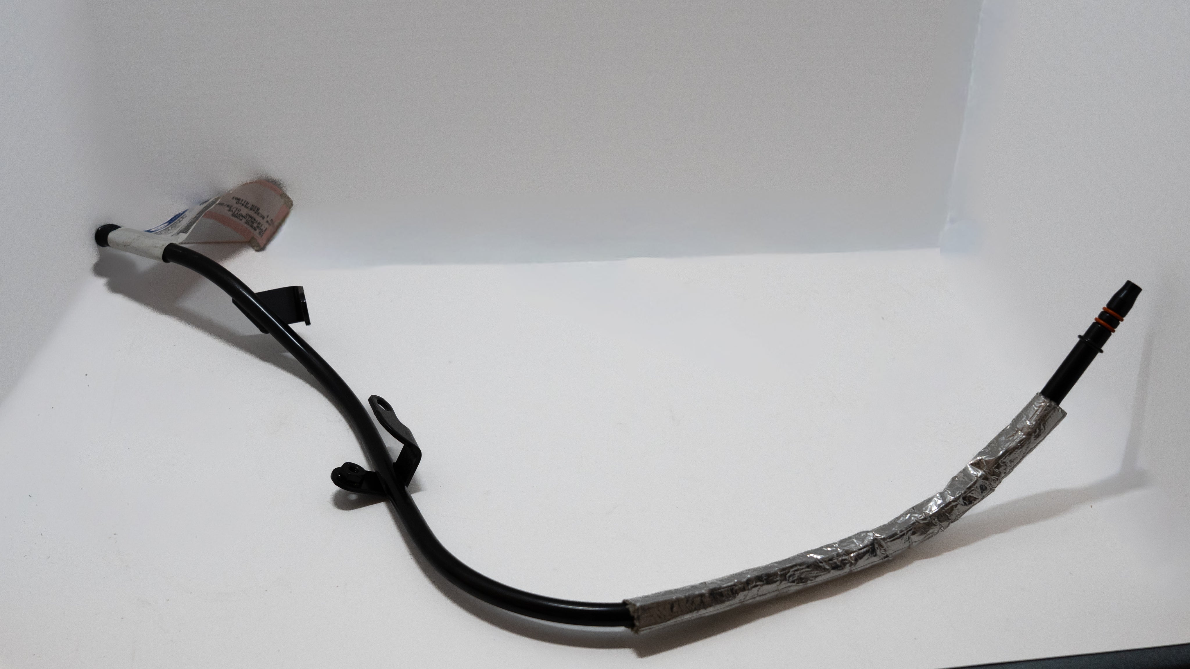 Black automotive oil dipstick tube on a white background. 
