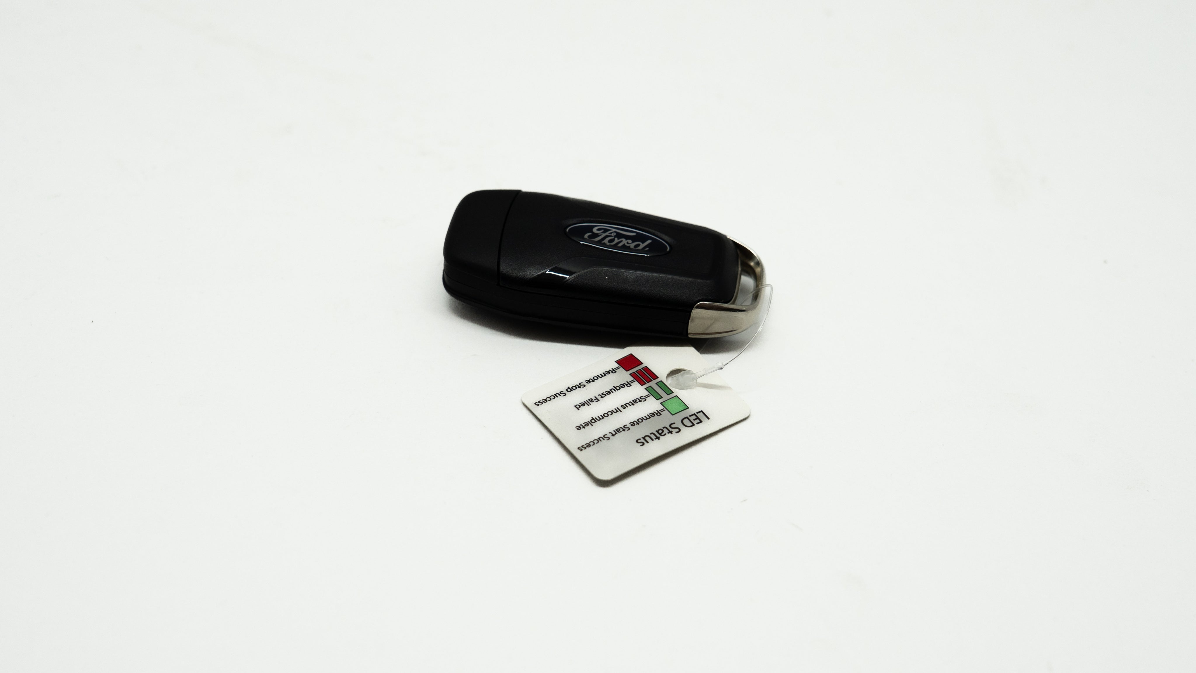Black car key fob with a card on a white background