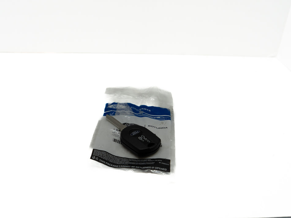 Black remote control automotive key fob in a clear plastic bag on a white background