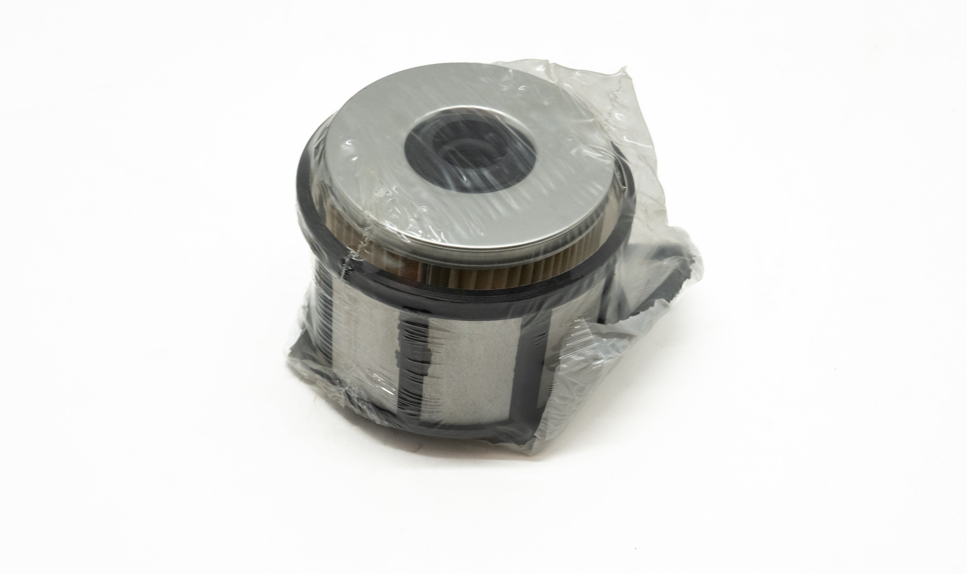 Automotive fuel filter wrapped in plastic on a white background
