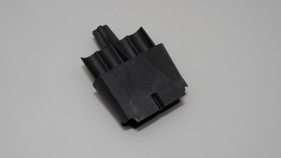 Black automotive plastic component on a gray background