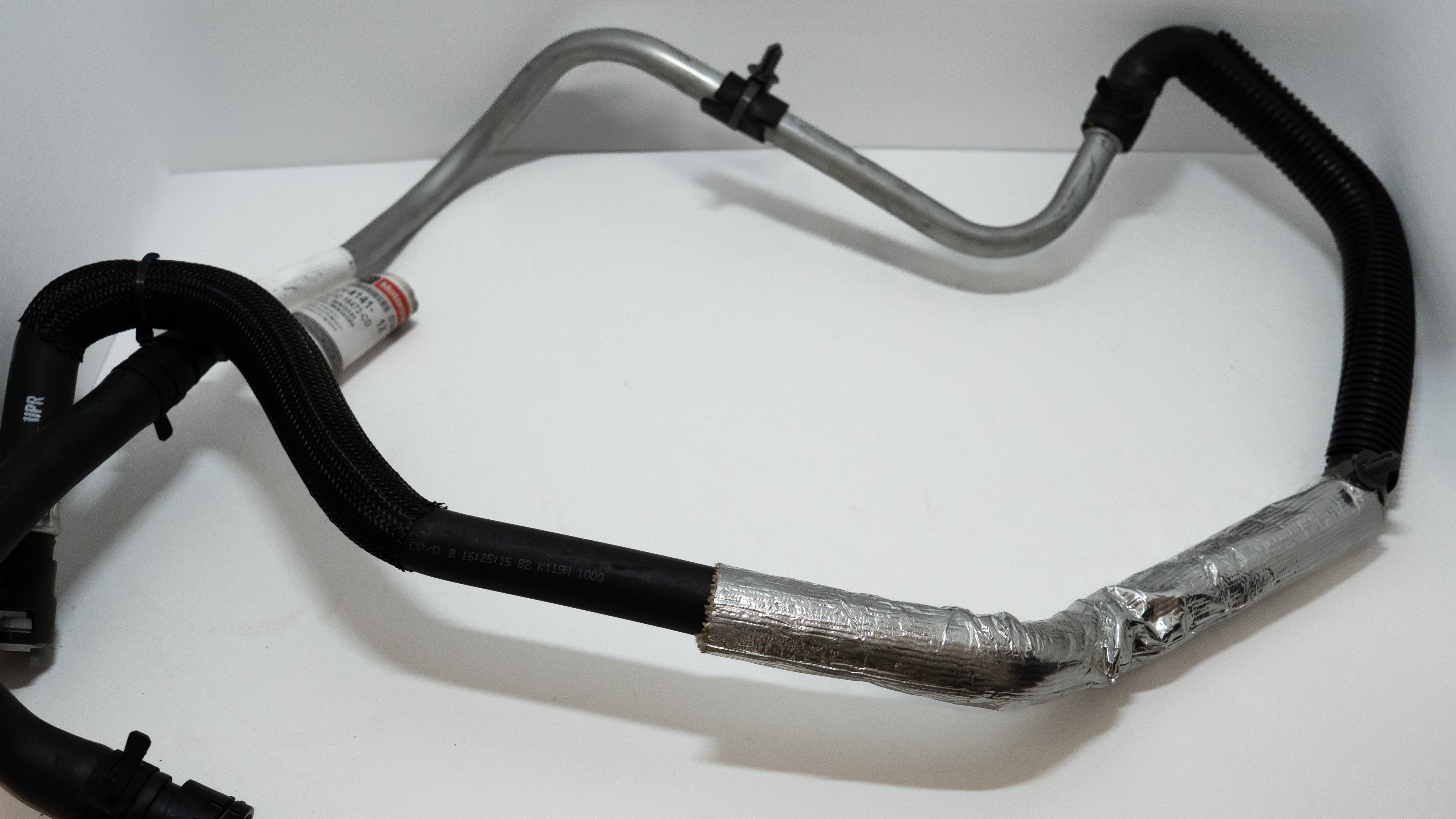 Set of automotive HVAC heater hoses on a white background