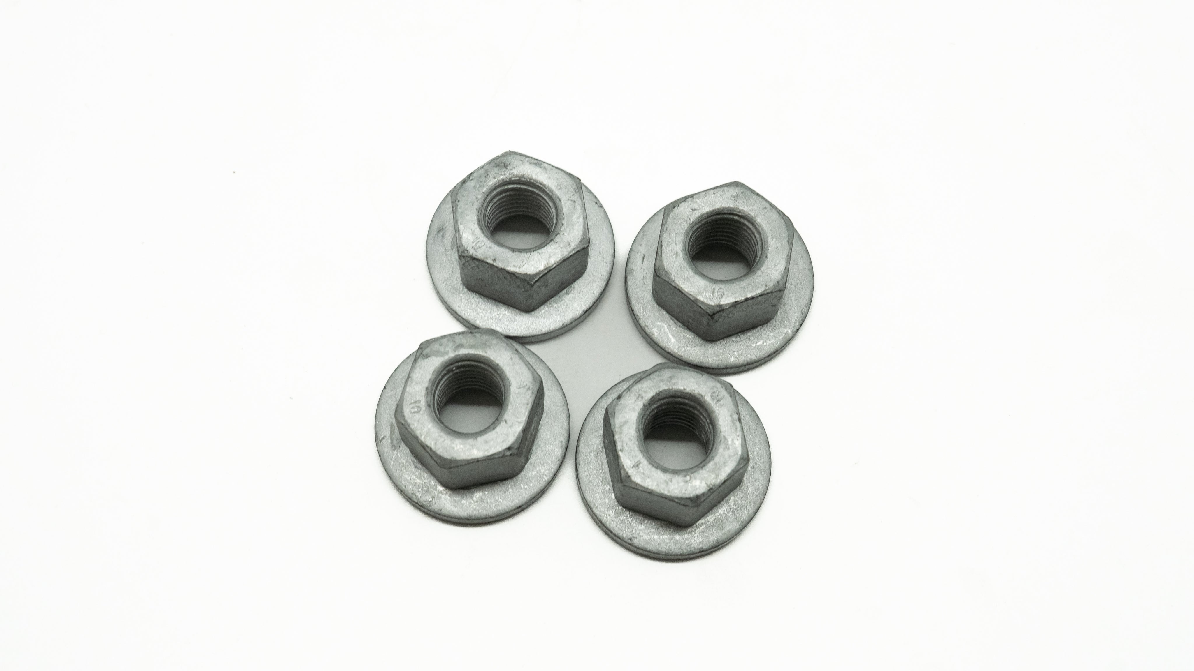 Four metal nuts on a white background