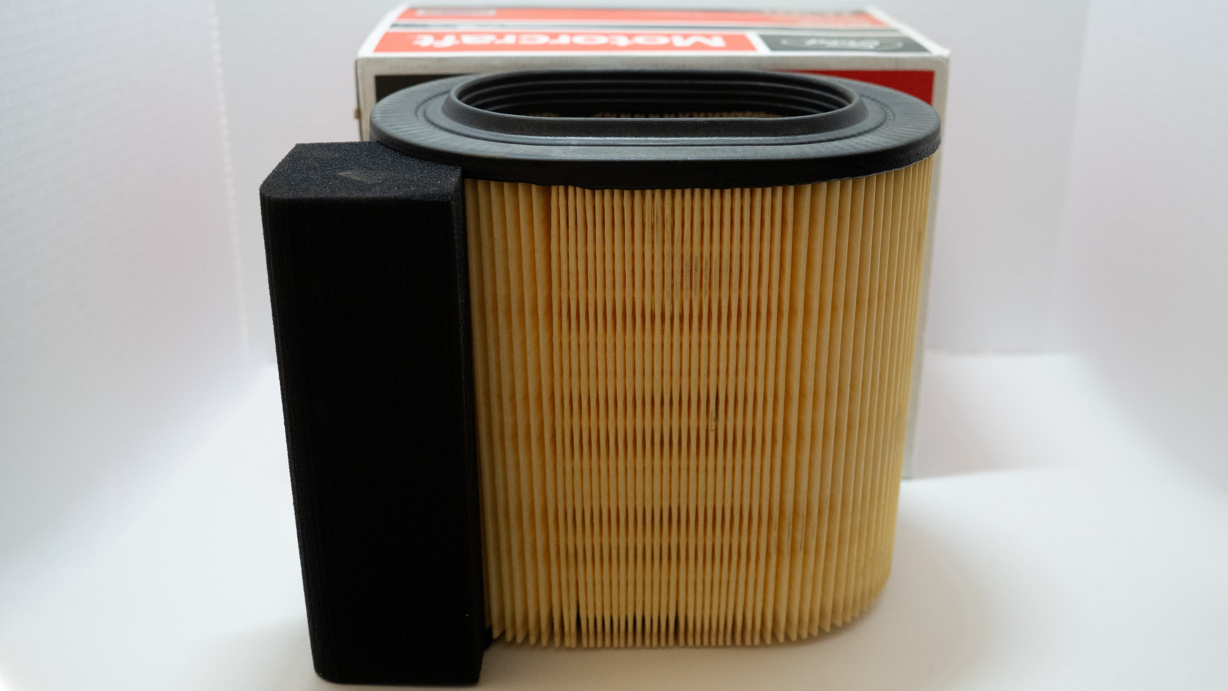 Engine air intake filter and assembly with packaging on a white background.