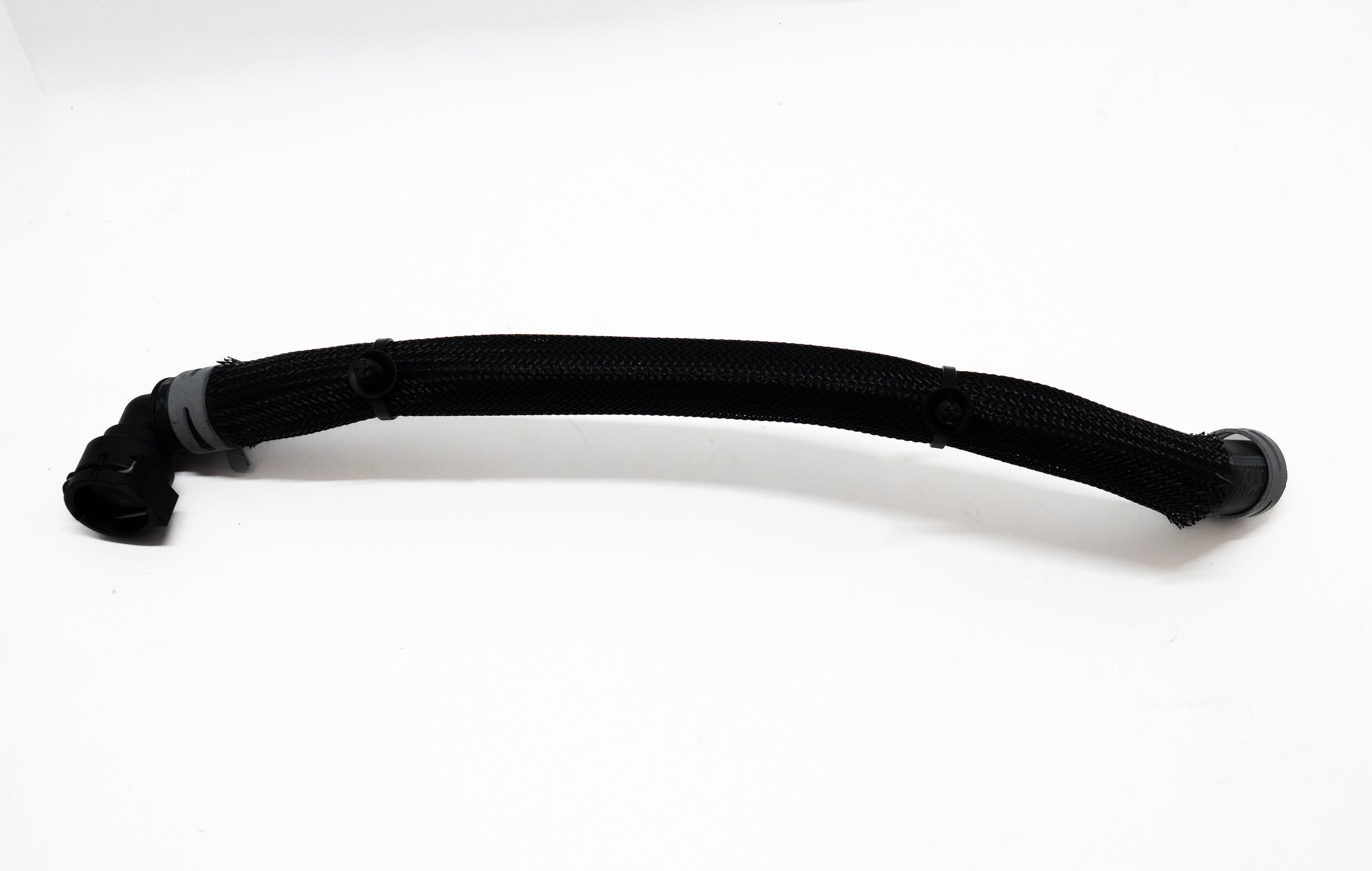 Black automotive hose with connectors on both ends on a white background.