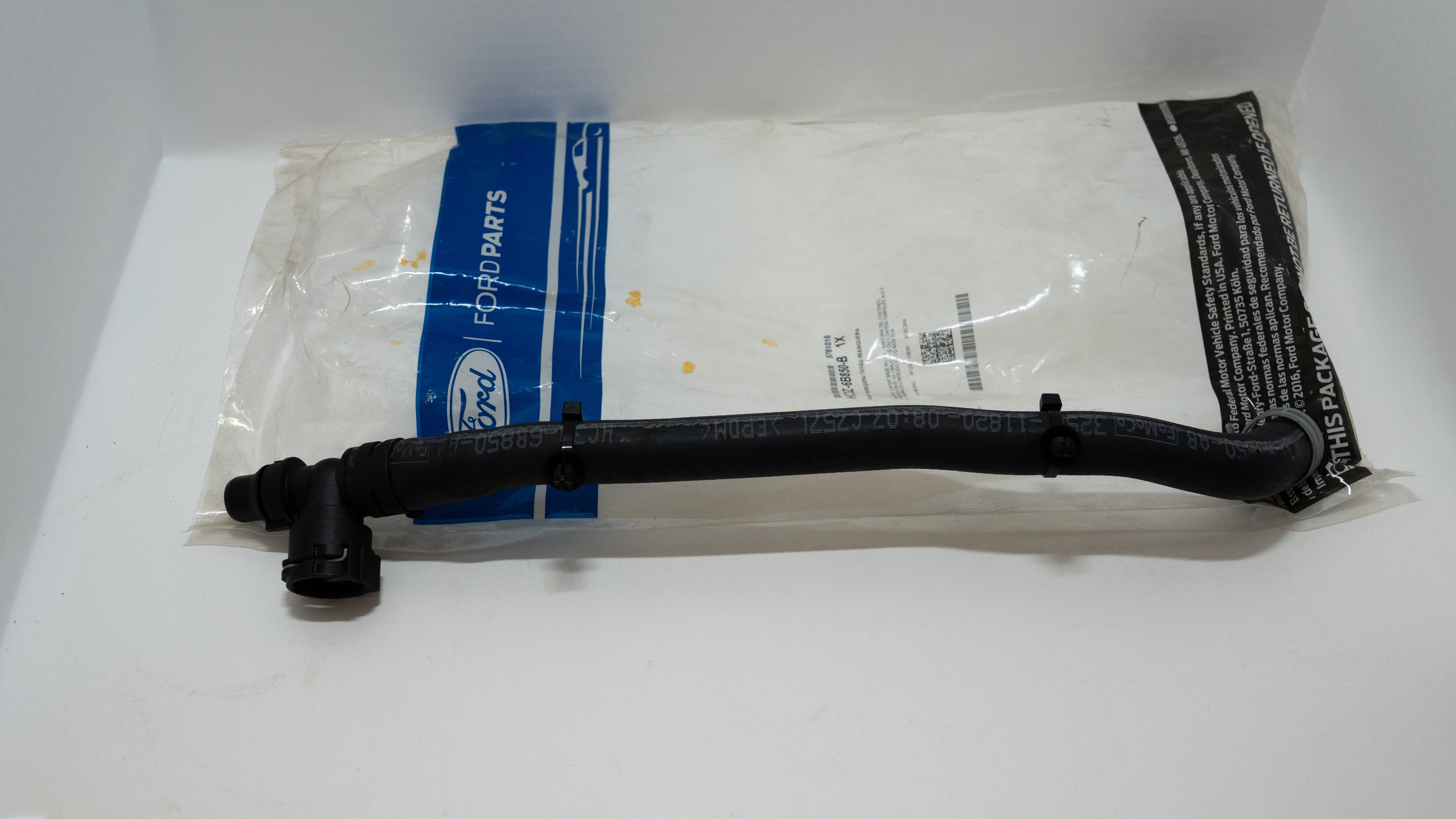 Black tube and connectors with Ford parts packaging on a white background.