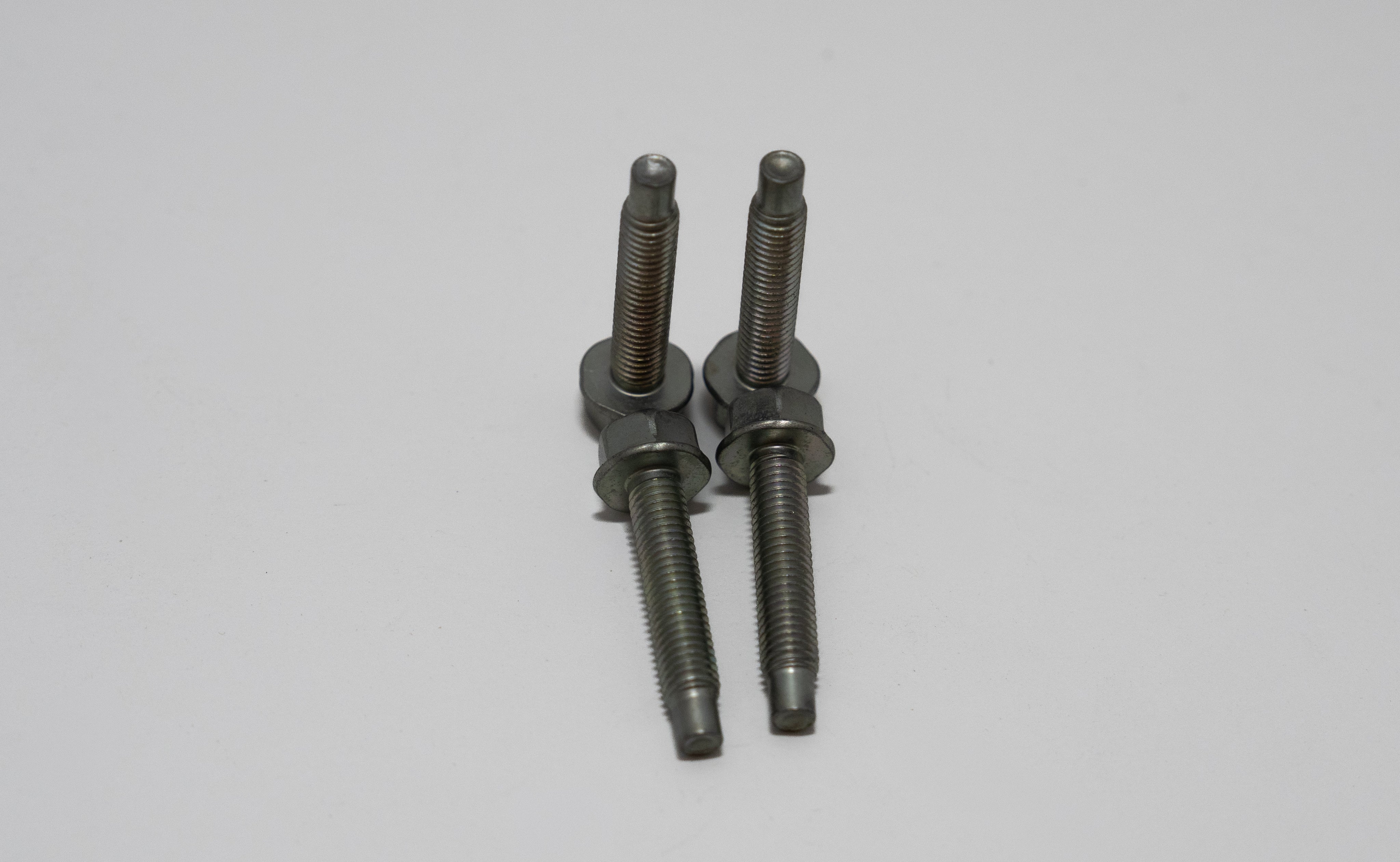 Two metal automotive screws on a gray background