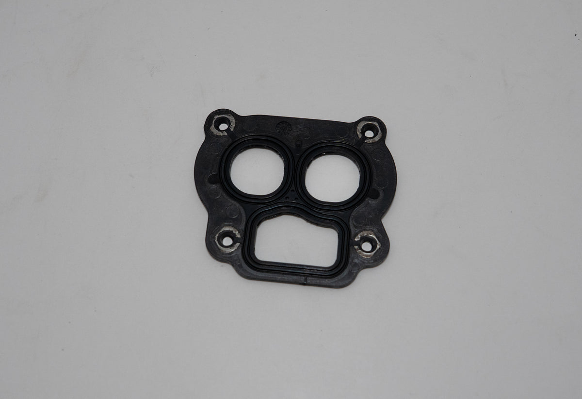 Black automotive gasket on a gray background.
