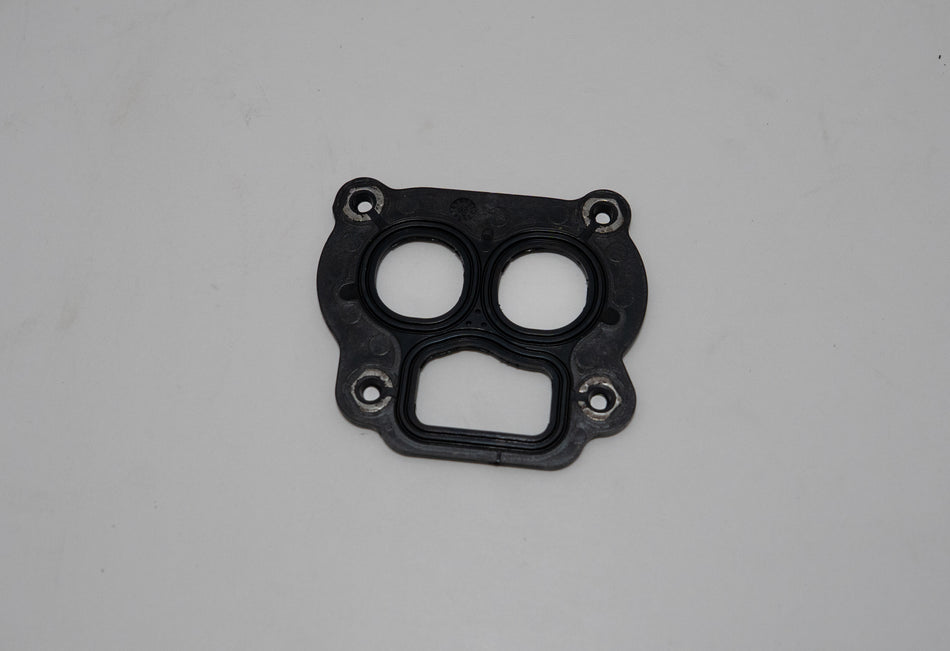 Black automotive gasket on a gray background.