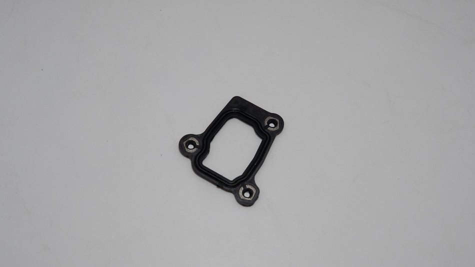 Black metal engine gasket on a gray background