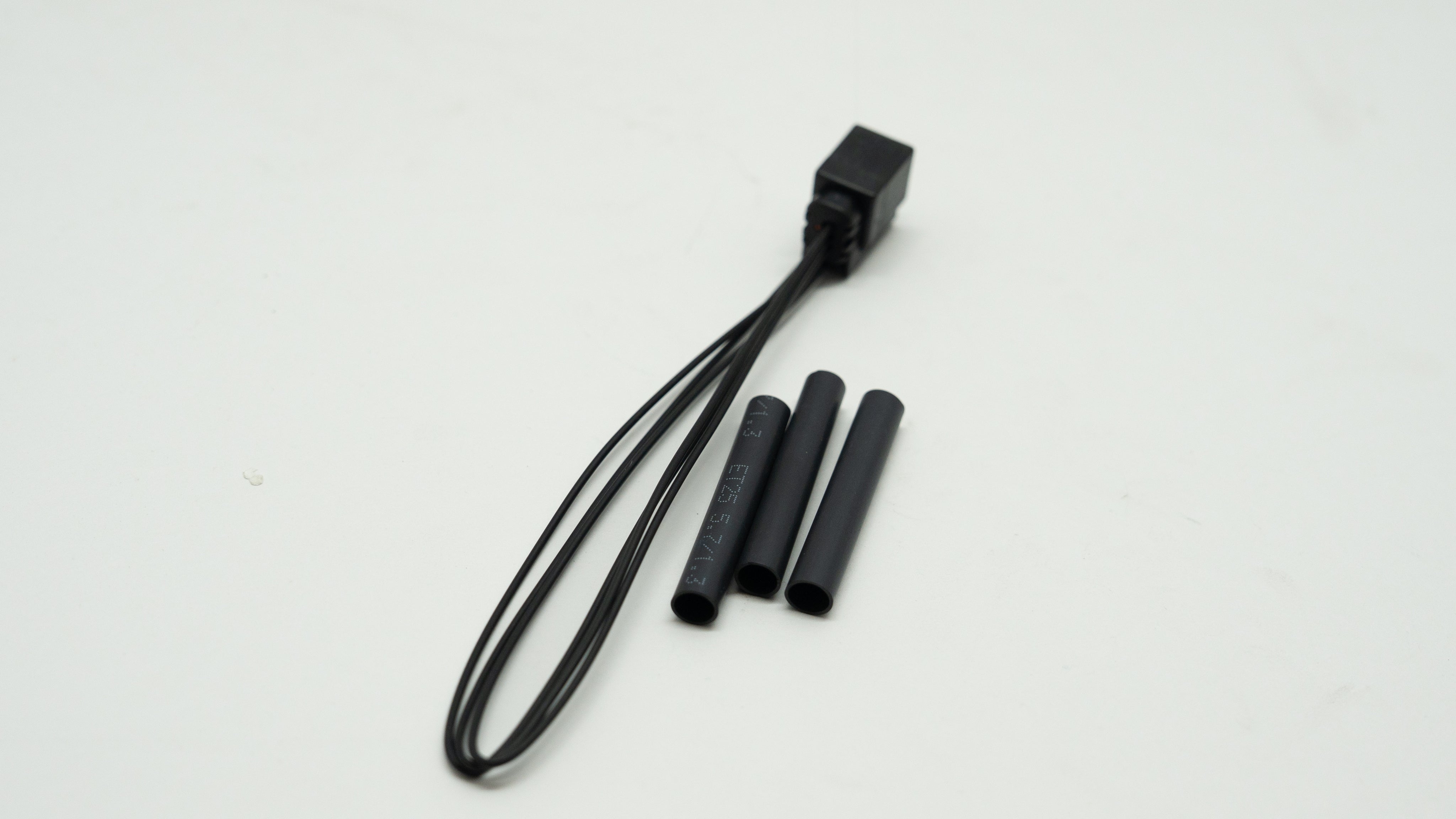 Black wiring kit with three black connectors on a white background
